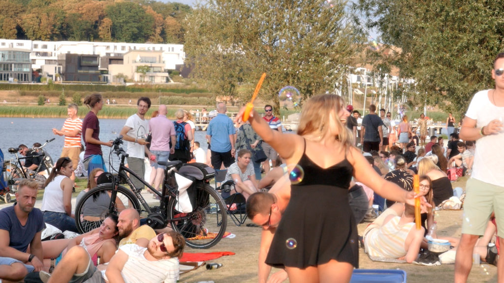 Das Bild zeigt eine Frau die am Phoenix See tanzt. Um sie herum sind Seifenblasen